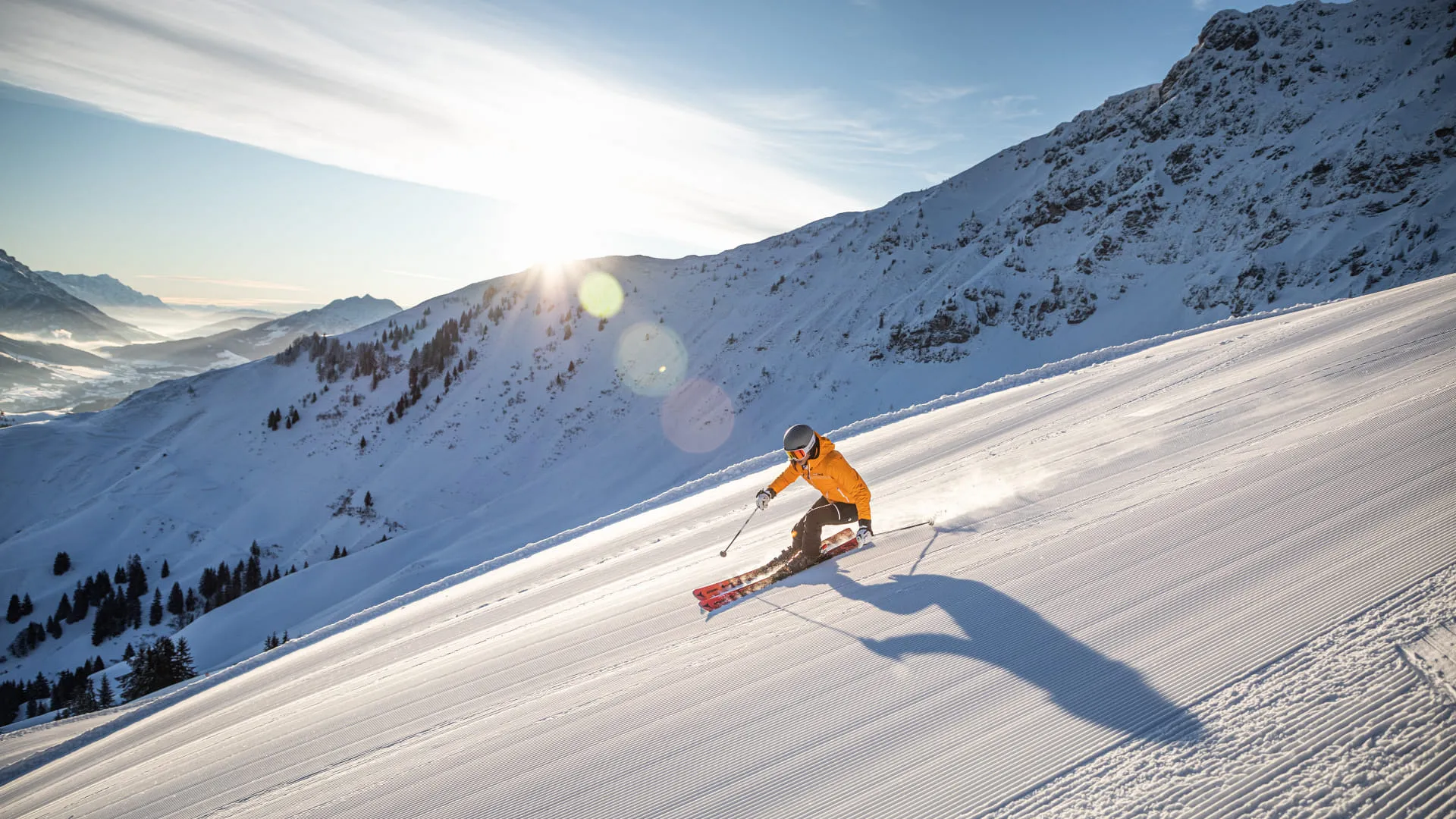 Skifahrer in einer Kurve auf der sonnigen Piste