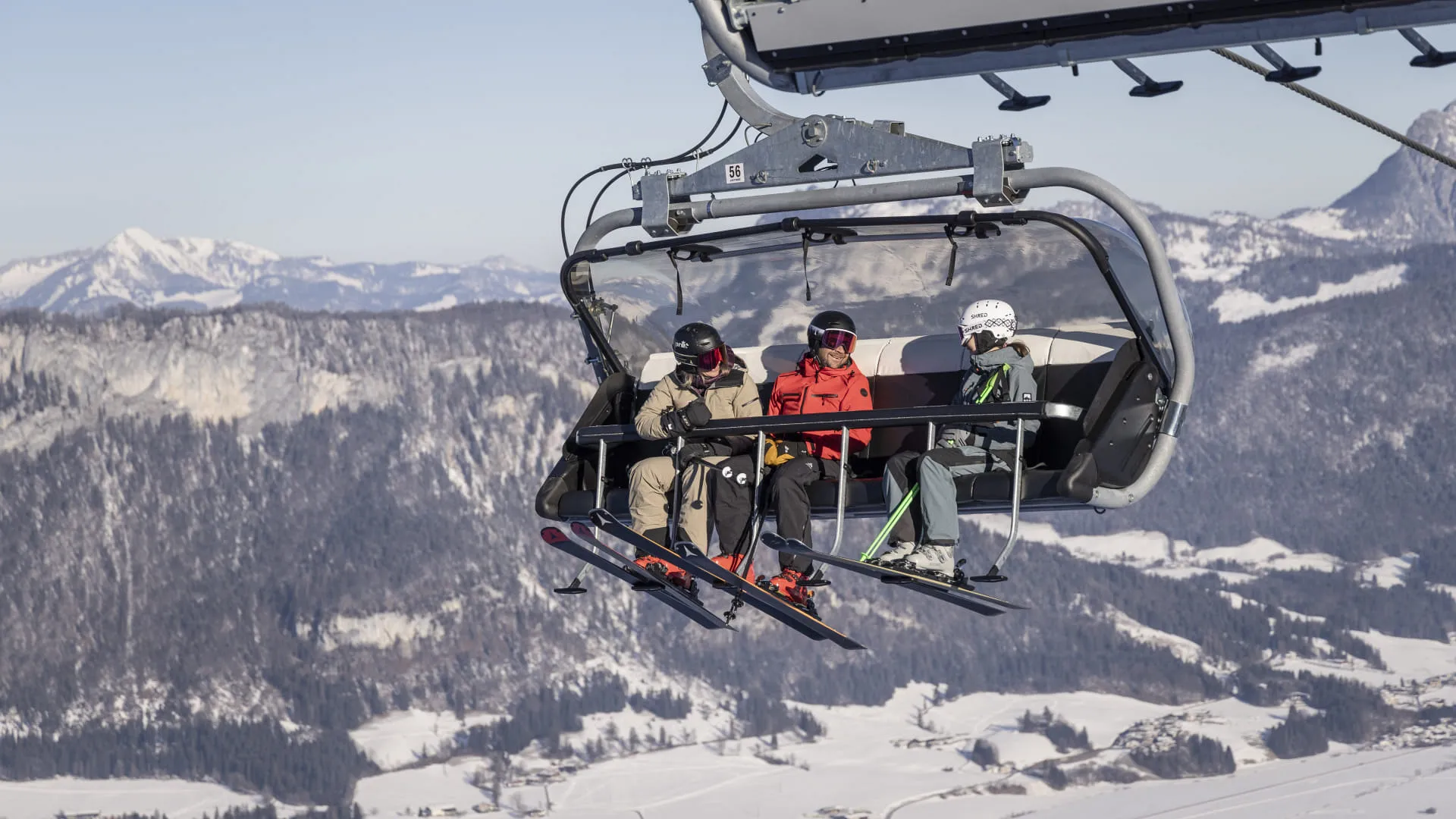 Skifahrer im Sessellift über der verschneiten Winterlandschaft