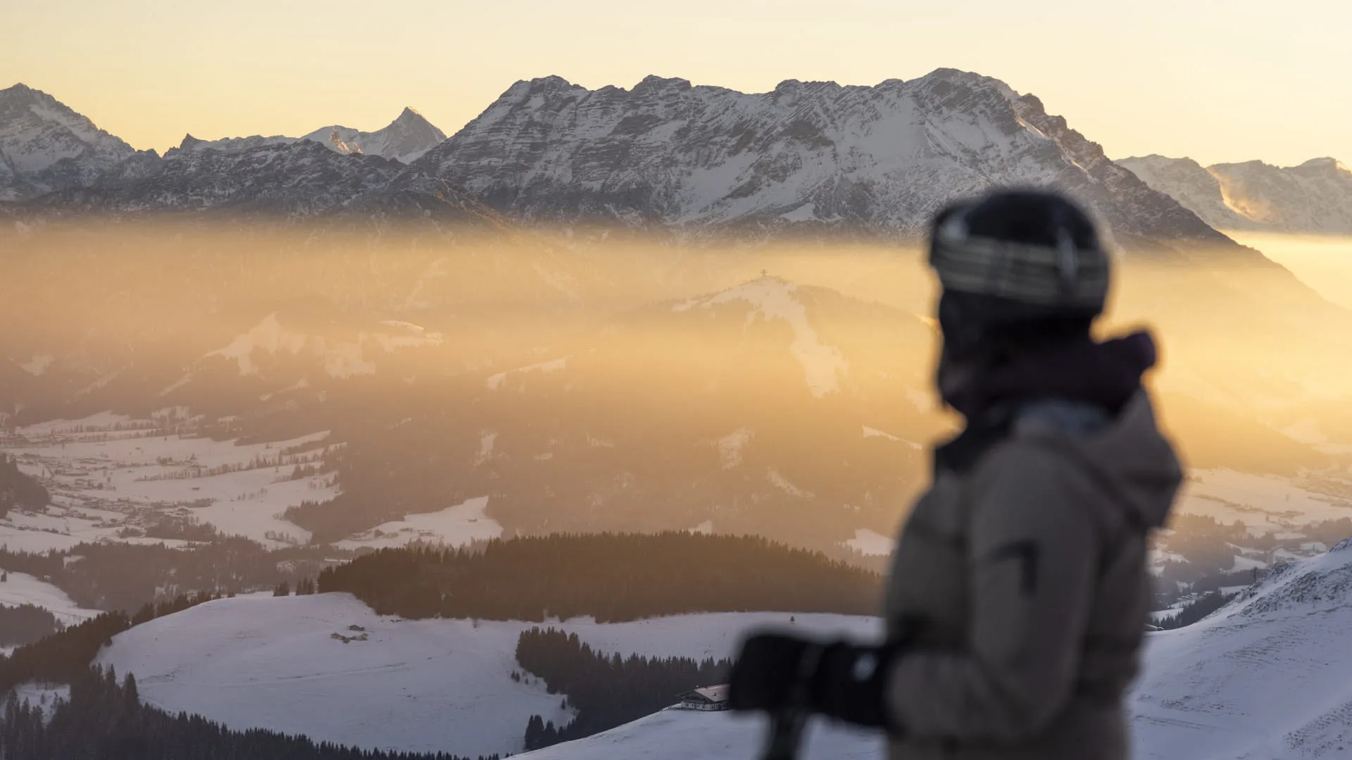 Skifahrerin bei Sonnenaufgang über dem Nebelmeer